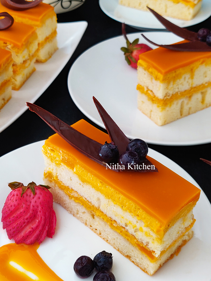 mango dessert, fusion mango dessert, how to make mango mousse cake, how to make mango mousse cake from scratch, mango mousse cake recipe, mango mousse with cake cookie base, mango mousse cake with mango glaze recipe, Mango Recipes, nitha kitchen cakes and bakes, nitha kitchen eggless baking recipes, nitha kitchen mango recipes, single serve mango dessert recipe, vanilla sponge cake filled with mango mousse , double layered vanilla cake with mango mousse filling, mango mousse filling for cakes, how to make chocolate strands, how to make chocolate triangle, chocolate decorations as cake topper, cake topper ideas, chocolate decoration ideas, mango mousse cake recipe, mango mousse cake, mango mousse cake video recipe, mango mirror glaze, mango glaze recipe, royal mango dessert, fusion mango dessert ideas